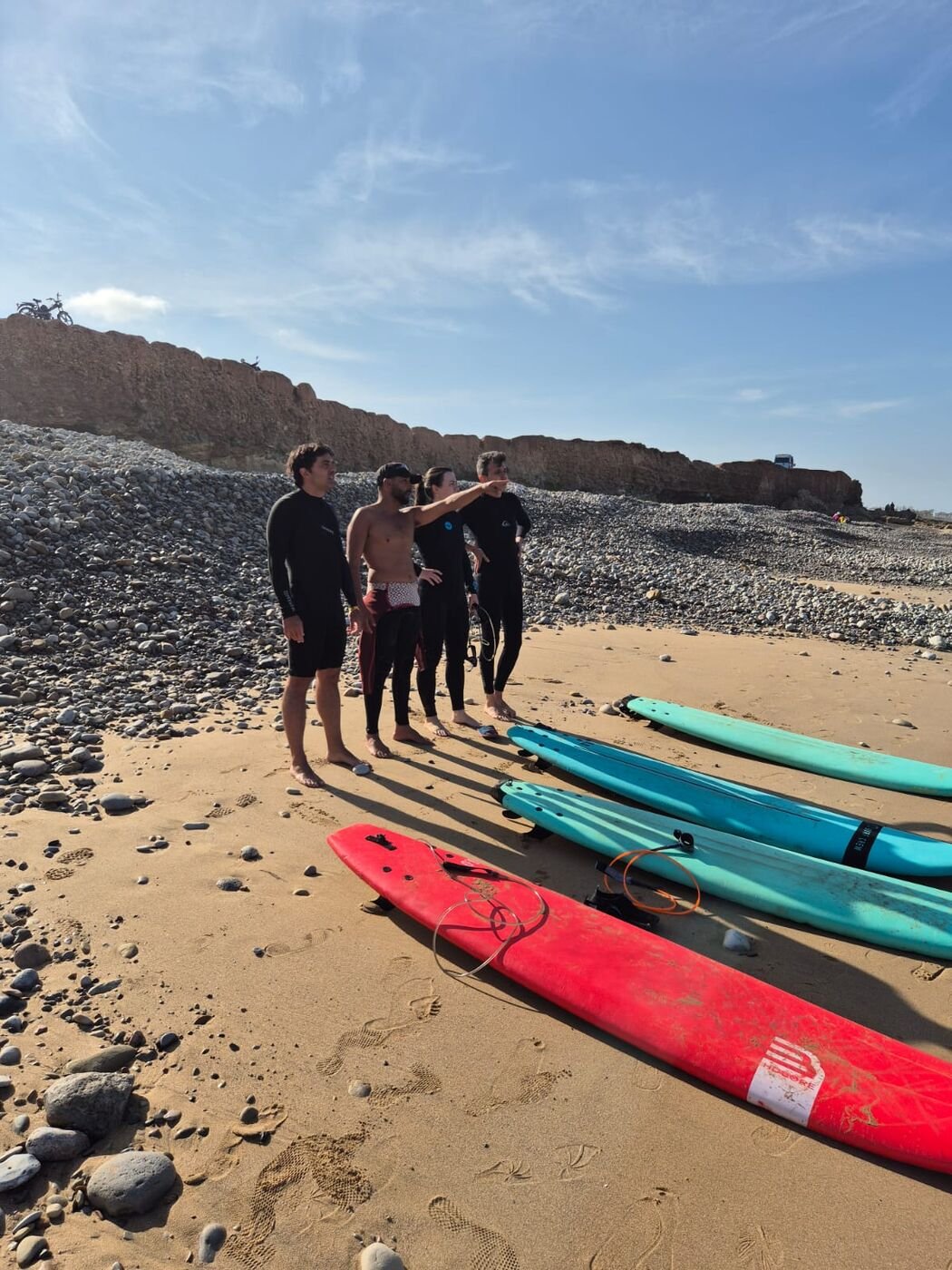 Coach pointing out the lineup with boards on the sand